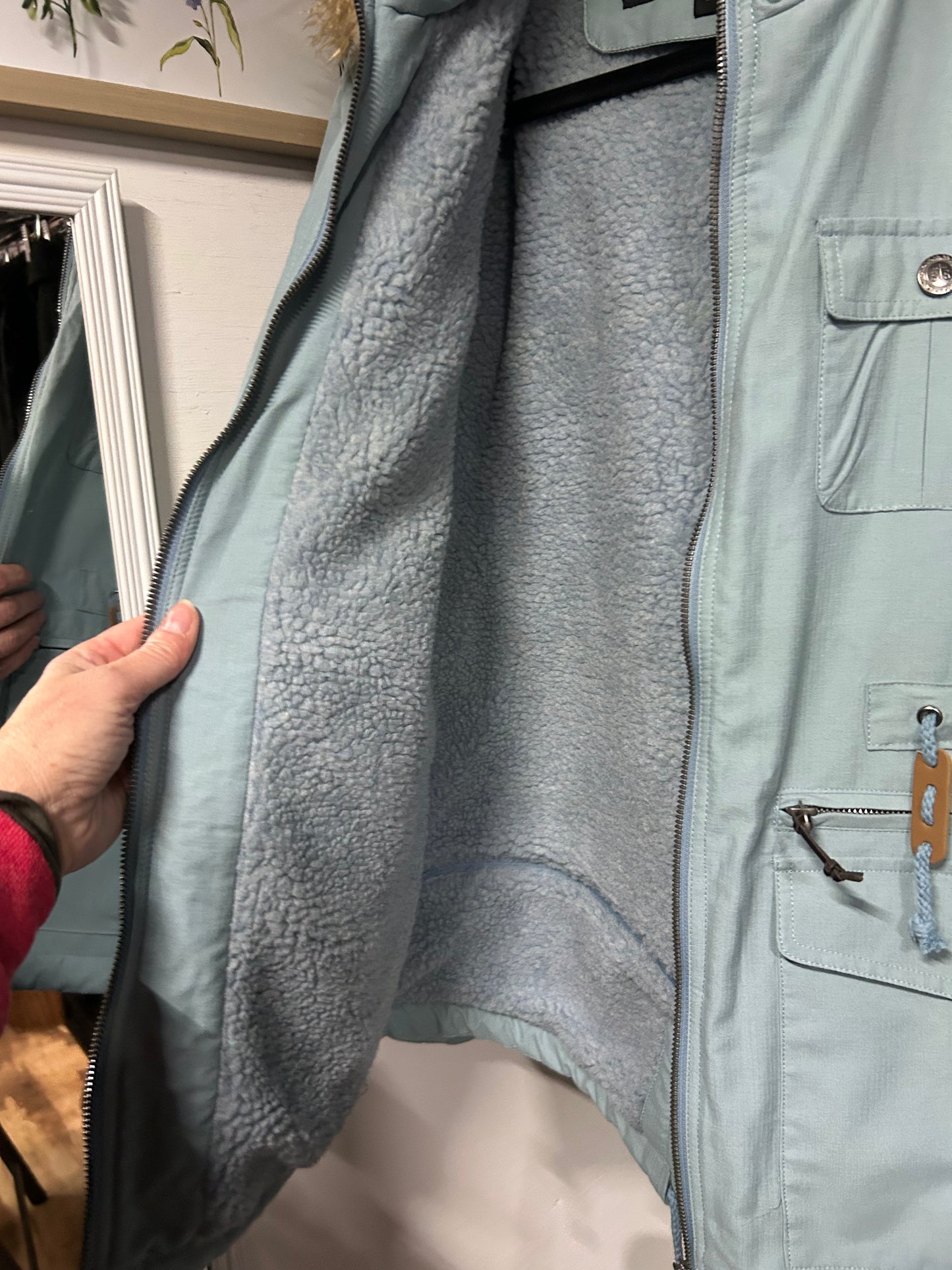 Light blue STS Ranchwear coat showing soft fleece lining and front snap pockets with zipper details