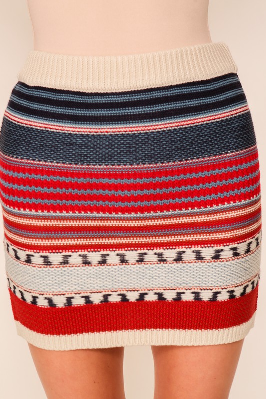 Close-up of a multicolor striped knit sweater mini skirt with red, blue, cream, and black patterns on a model